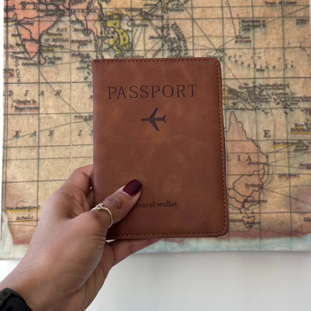Hand holding Brown RFID Passport Holder in front of map